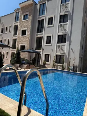 a large swimming pool in front of a building at Apartment with balcony sea view and Parking B12 in Budva