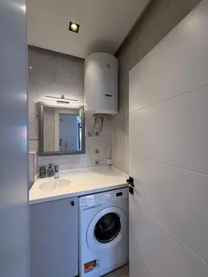 a small kitchen with a washing machine and a sink at Apartment with balcony sea view and Parking B12 in Budva