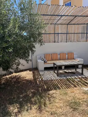 a bench sitting in a yard next to a wall at Villa Alidah Avkoppling med utsikt, pool och fruktträd in Bar