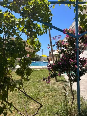 a garden with flowers and a blue pole at Villa Alidah Avkoppling med utsikt, pool och fruktträd in Bar