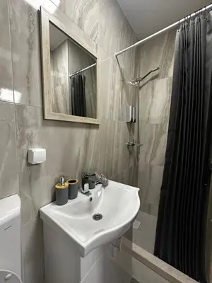 a white bathroom with a sink and a shower at Apartments ML in Kotor