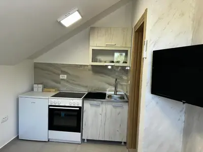 a small kitchen with a sink and a stove at Apartments ML in Kotor