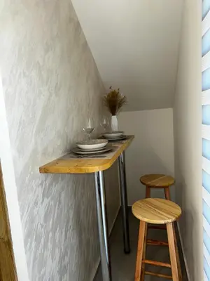 a table in a room with two stools at Apartments ML in Kotor
