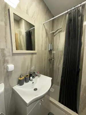 a white bathroom with a sink and a shower at Apartments ML in Kotor