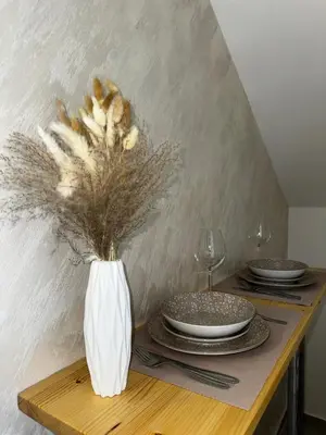 a table with a vase with dried flowers in it at Apartments ML in Kotor