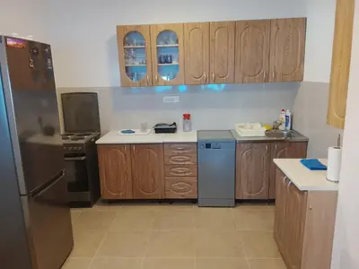 a kitchen with wooden cabinets and a stainless steel refrigerator at House with pool and seaview in Kuljače