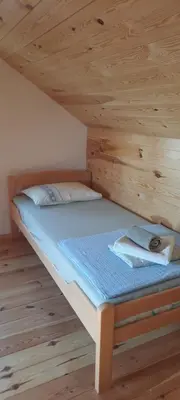 a bed in a room with a wooden ceiling at House with pool and seaview in Kuljače