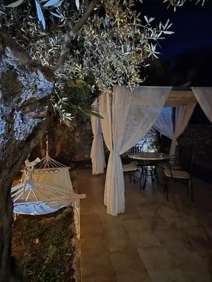 a pavilion with white curtains and a table and chairs at Vista Blue Villa in Budva