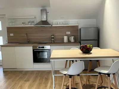 a kitchen with a table with a bowl of fruit on it at Petra & Vuk Apartments Kotor in Kotor