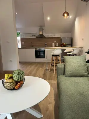 a kitchen and living room with a couch and a table at Petra & Vuk Apartments Kotor in Kotor