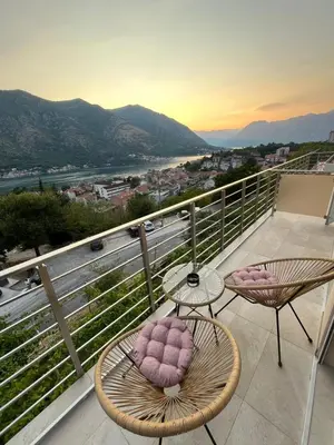 a balcony with two chairs and a view of a city at Petra & Vuk Apartments Kotor in Kotor