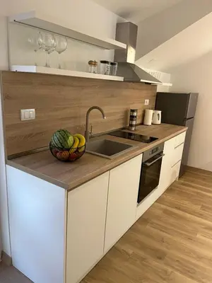 a kitchen with a sink and a bowl of fruit on a counter at Petra & Vuk Apartments Kotor in Kotor