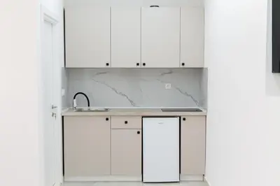 a kitchen with white cabinets and a sink at Diamonds Xh&A Apartments in Ulcinj