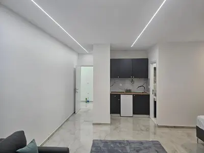 an empty living room and kitchen with white walls at Diamonds Xh&A Apartments in Ulcinj