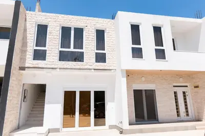 a house with white walls and windows at Diamonds Xh&A Apartments in Ulcinj