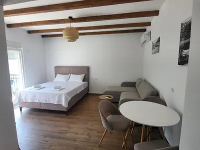 a bedroom with a bed and a table and chairs at Riječki grad Apartments in Rijeka Crnojevića