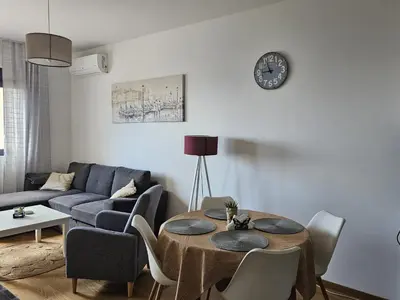 a living room with a table and a couch at Apartament Onyx in Becici
