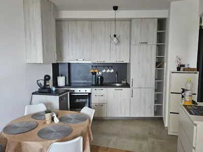 a kitchen with a table and chairs in a room at Apartament Onyx in Becici