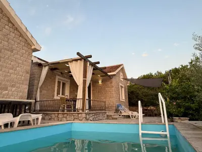 a house with a swimming pool and a patio at Golden Ray Bigova in Bigovo