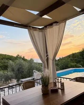 a patio with a table and a view of a pool at Golden Ray Bigova in Bigovo