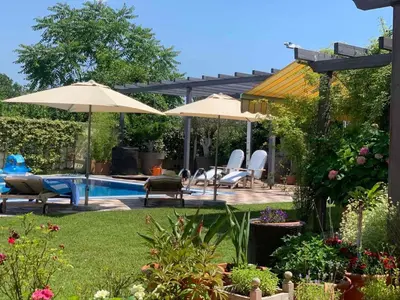 a patio with umbrellas and a swimming pool at Andrej home in Šušunja