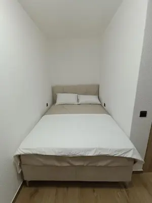 a bed in a small room with white walls at ApartmentsMD apartman 1 za pravi odmor in Sutomore