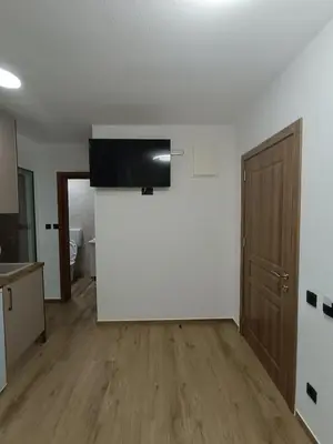an empty room with a white wall and a wooden floor at ApartmentsMD apartman 1 za pravi odmor in Sutomore