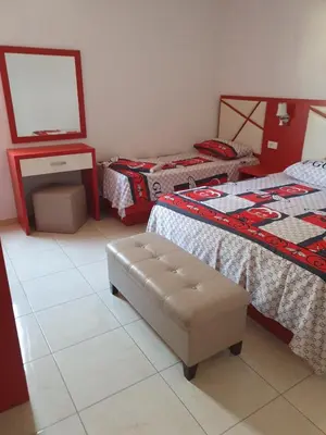 a room with two beds and a ottoman in it at Apartman OAZA 4 in Ulcinj