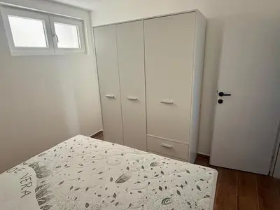 a bedroom with a bed and a closet and a window at Harmonia in Dobra Voda