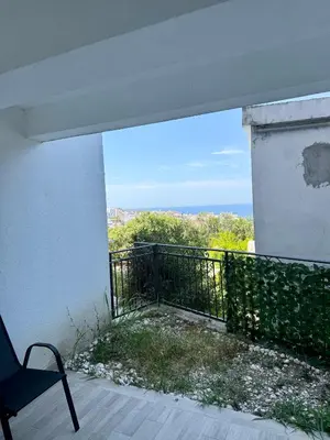 a balcony with a chair and a view of the ocean at Harmonia in Dobra Voda