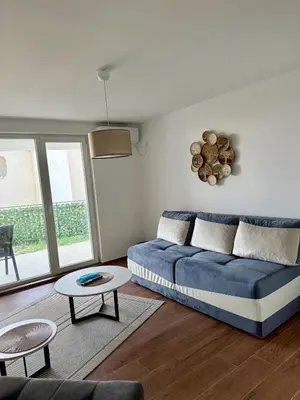 a living room with a blue couch and a table at Harmonia in Dobra Voda