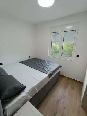 a white bedroom with a bed and two windows at ApartmentsMD apartment 3 for real enjoyment in Sutomore