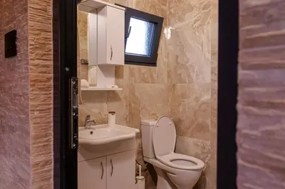 a bathroom with a toilet and a sink and a window at Nina in Golubovci