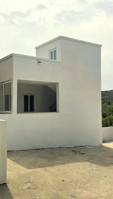 a white house with a large garage at Aqua Apartments in Bigovo