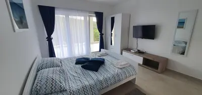 a bedroom with a bed with blue pillows on it at Aqua Apartments in Bigovo