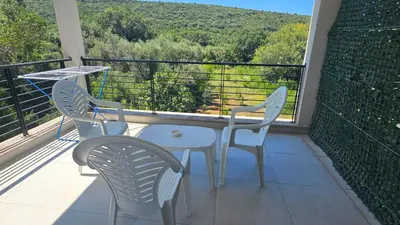 two chairs and a table on a balcony with a view at Aqua Apartments in Bigovo