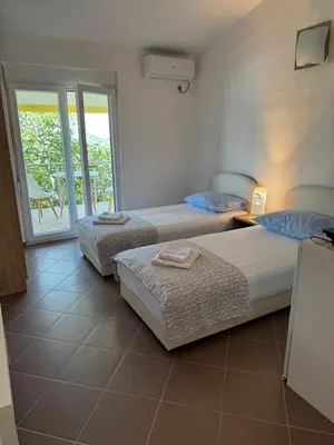 a bedroom with two beds and a balcony at Apartmani Sutomore in Sutomore