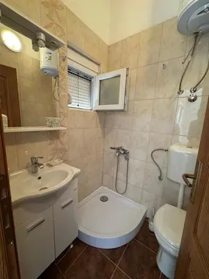 a bathroom with a sink and a toilet and a shower at Apartmani Sutomore in Sutomore