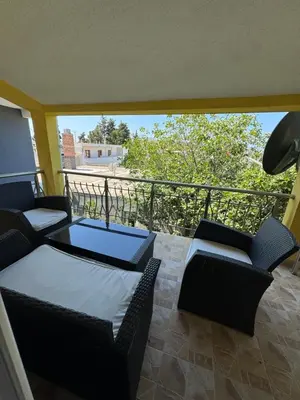 a balcony with two couches and a table and chairs at Apartmani Sutomore in Sutomore