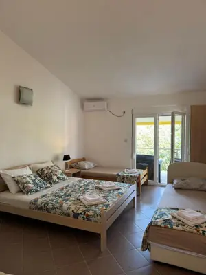 a bedroom with two beds and a window at Apartmani Sutomore in Sutomore