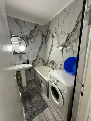 a bathroom with a washer and dryer and a sink at Zagi Apartment in Ulcinj