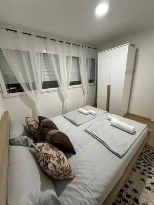 a bedroom with a large bed with white sheets and pillows at Zagi Apartment in Ulcinj
