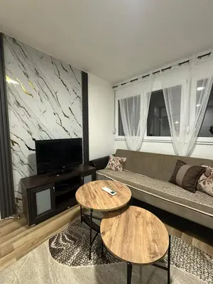 a living room with a couch and two tables at Zagi Apartment in Ulcinj