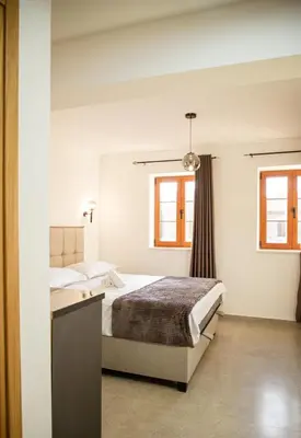 a bedroom with a bed and two windows at Villa Terra Promessa in Ulcinj