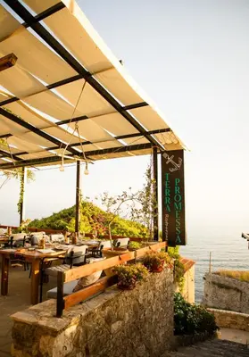 a patio with tables and chairs and the ocean at Villa Terra Promessa in Ulcinj