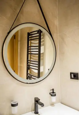 a bathroom with a round mirror above a sink at Villa Terra Promessa in Ulcinj