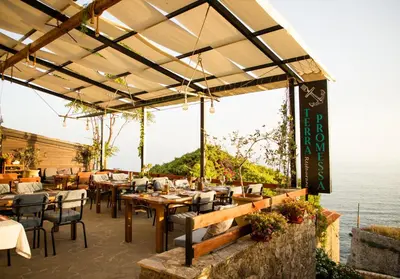 a restaurant with tables and chairs and a view of the ocean at Villa Terra Promessa in Ulcinj