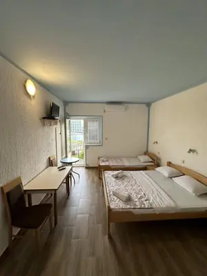 a room with two beds and a table and chairs at Atlantic-Moj market in Boreti