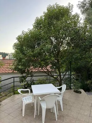 a white table and chairs on a patio with a tree at Atlantic-Moj market in Boreti