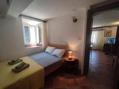 a small bedroom with a bed and a candle on a table at Radimir 101 in Kotor